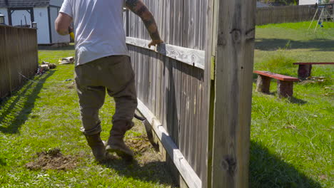 Worker-begins-to-dig-a-hole-with-a-shovel-for-fence-repair