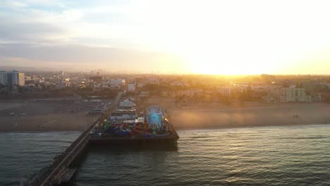 Gorgeous-aerial-fly-over-ferris-wheel-in-Santa-Monica-during-sunrise-golden-hour