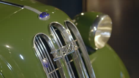 Front-radiator-grill-and-headlamp-of-classic,-green,-luxury-car-Ford-Vairogs