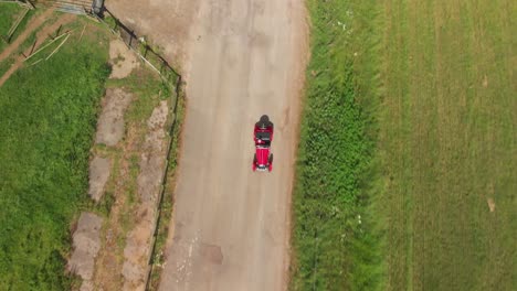 Roter-1939er-Morgan-4-4-„Le-Mans“-–-Drohnenansicht-Beim-Verlassen-Einer-Farm-–-4K-–-Offener-Sportwagen-In-Der-Englischen-Landschaft-An-Einem-Bilderbuchtag