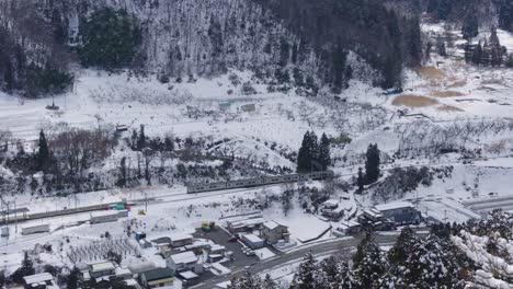 Train-traveling-over-rural-snow-covered-landscape-of-Yamagata-Japan