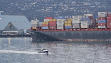 A-Ship-With-Container-Vans-And-A-Boat-Cruising-In-Opposite-Direction-At-Brockton-Point,-Stanley-Park,-Vancouver,-BC---Medium-Shot