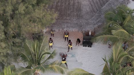 Vista-Aérea-Con-Vista-A-Un-Colorido-Grupo-De-Bailarines-Atléticos-En-La-Playa-Michamvi-Kae-En-Zanzíbar