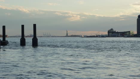 La-Estatua-De-La-Libertad-En-La-Ciudad-De-Nueva-York-Durante-La-Hora-Dorada-Desde-El-Otro-Lado-Del-Puerto-Y-El-Río-Este