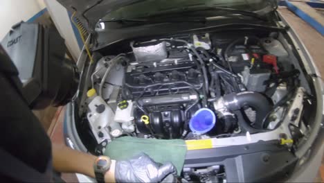 Mechanic-Grabs-Bottle-Of-Transmission-Fluid-Opens-It-And-Fills-Car-With-It-From-A-First-Person-Perspective