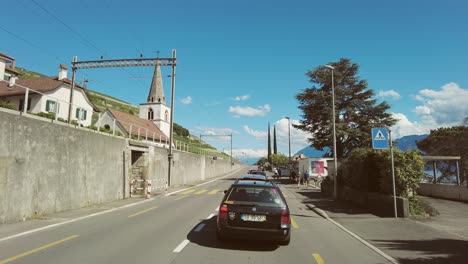 Helicopter-fertiliser-spreading-Lavaux-vineyards-between-Lausanne-to-Montreux,-sunny-day,-cars,-road,-clear-sky