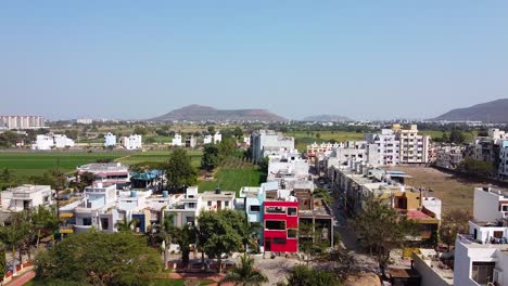 A-combination-of-Village-and-city-aerial-view-drone-shot-with-big-mountain-in-back-I-Drone-shot-of-small-city-near-a-village-farms-and-feilds-in-India