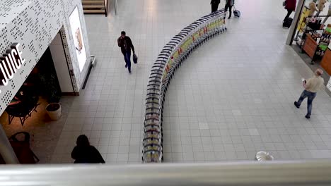 Trolleys-moving-together-like-a-snake-in-airport-shot-from-above