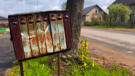 Rusted-mailbox-next-to-rural-road-in-the-Baltics-remote-wide-angle-daytime