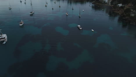 Toma-Aérea-De-Una-Isla-En-España-Con-Muchos-Barcos,-Volando-Hacia-Atrás-E-Inclinándose-Hacia-Arriba,-4k-Uhd