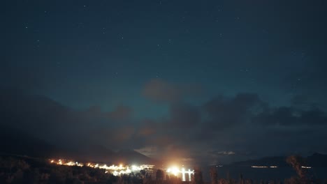 Cielos-Nocturnos-Iluminados-Por-La-Aurora-Boreal-Sobre-El-Puerto-Brillantemente-Iluminado-Y-El-Oscuro-Fiordo