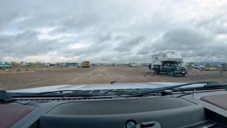 POV-driving-on-gravel-trail-to-approach-groups-of-dispersed-campers-in-the-Sonoran-desert-on-a-cloudy-winter-day-in-southern-Arizona