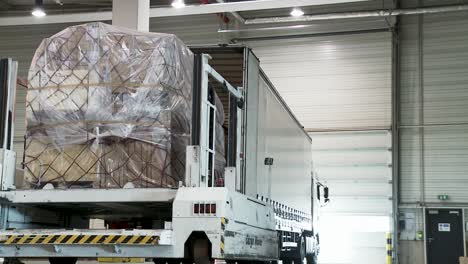 Loading-dock-with-cargo-trucks-open-and-packed-with-various-goods-in-a-warehouse-facility