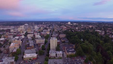 Panorámica-Aérea-A-Través-De-Una-Ciudad-En-La-Bahía-Al-Atardecer-Con-Cielos-Tormentosos