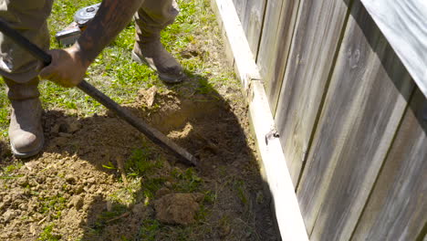 Using-a-prybar-to-dig-out-rotten-wooden-post