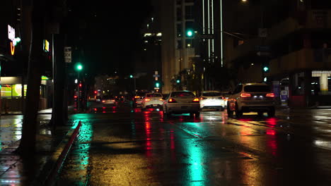 Traffic-in-Downtown-Los-Angeles-USA-on-Rainy-Night,-Cars-and-Street-Lights-Reflections-on-Wet-Road,-Slow-Motion