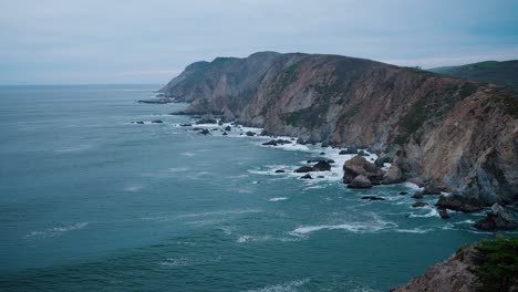 Düstere-Und-Launische-Aufnahme-Von-Wellen,-Die-Gegen-Felsen-Und-Klippen-Im-Pazifik-Krachen