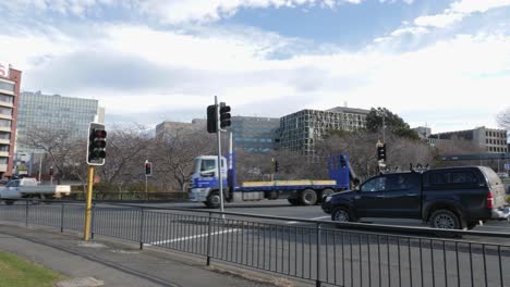 Los-Vehículos-Pasan-Por-La-Rotonda-ABC-Con-El-Edificio-Menzies-Al-Fondo-En-Hobart,-Tasmania.