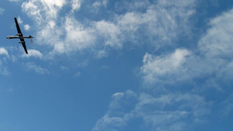 Military-Drone-flying-across-the-sky-during-a-bright-sunny-day