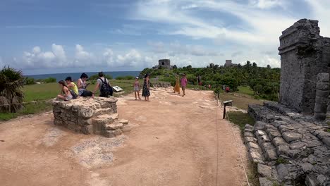 Turistas-Visitando-Las-Ruinas-De-La-Antigua-Ciudad-De-Tulum-Junto-Al-Mar