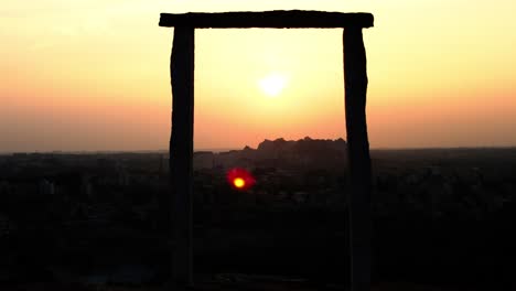 Toma-De-Lapso-De-Tiempo-De-Una-Hermosa-Puesta-De-Sol-Detrás-De-Una-Colina-Y-Un-Marco-De-Granito-En-Primer-Plano