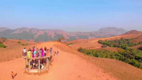 Aerial-shot-flying-around-an-observation-point-with-people-on-it-overlooking-rolling-hills-and-grasslands