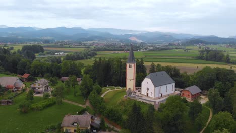 Aerial-view-of-a-church-and-village-on-top-of-the-hill-with-landscape-and-mountains-as-background-in-Europe