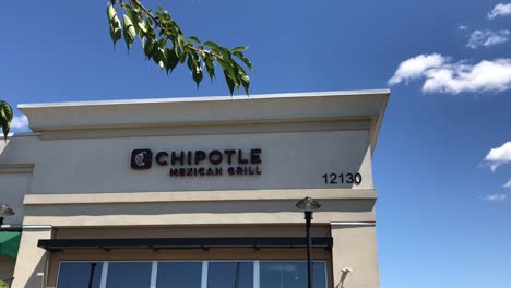 El-Exterior-De-Un-Restaurante-Tex-mex-Informal-Rápido-De-Chipotle-En-Un-Centro-Comercial-En-Portland,-Oregon,-Ee.uu.-Con-Una-Bandeja-De-Mano-A-Través-De-Algunos-árboles