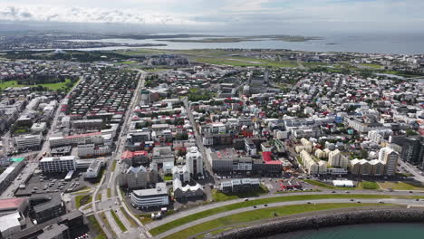 Aerial-View-of-Reykjavik,-Iceland-on-Sunny-Day,-City-Center-Buildings-and-Coastal-Traffic,-Drone-Shot