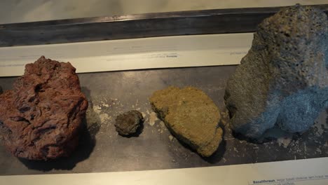 Different-Types-of-Volcanic-Rocks-in-Museum-Exhibit,-Close-Up