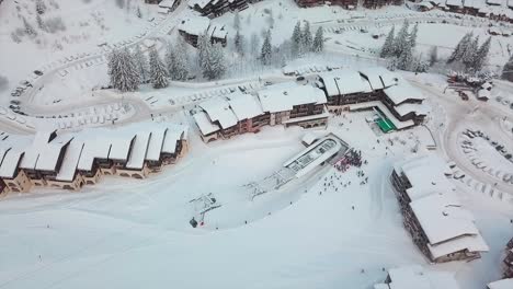 Vista-{aérea}-De-Un-Dron-Sobre-Una-Estación-De-Esquí-Nevada-Francesa-Durante-El-Invierno