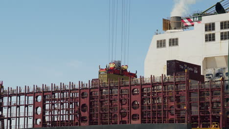 Crane-placing-container-on-an-empty-cargo-ship-in-the-port-of-Valencia,-Spain