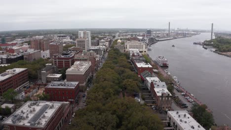 Low-aerial-shot-flying-over-Emmet-Park-towards-downtown-Savannah,-Georgia