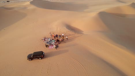 Vista-Aérea-De-Amigos-Haciendo-Barbacoa-En-El-Desierto-De-Abu-Dhabi,-Emiratos-Árabes-Unidos.