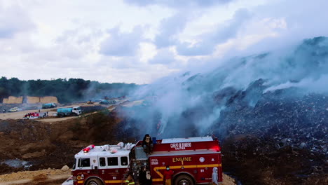 Aéreo,-Disparo-De-Un-Dron-Sobre-Camiones-De-Bomberos-Que-Luchan-Contra-Un-Incendio-Forestal,-En-La-Naturaleza-Llena-De-Humo,-En-Un-Día-Nublado,-En-Santo-Domingo,-República-Dominicana