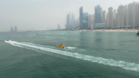 Dubai-Marina,-Hohe-Landschaftsansicht-Der-Jumeirah-Beach-Residence-Mit-Booten,-Die-Tagsüber-Das-Meer-überqueren