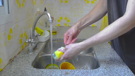 Male-person-doing-dishes-at-home