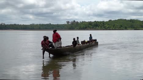 Group-of-people-on-river-in-traditional-dugout-canoe-with-outboard-motor
