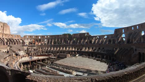 inside-the-Colosseum-in-Rome,-Italy-on-a-beautiful-day-in-spring-with-blue-sky-and-white-clouds