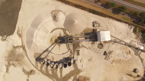 A-sandy-silo-with-trucks-moving-around-the-perimeter-of-the-refining-equipment