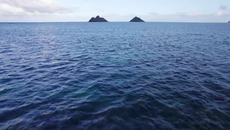 drone-footage-skinning-the-blue-Pacific-ocean-water-approaching-two-islets-of-the-coast-of-Oahu-Hawaii