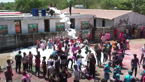 En-La-Cámara-Del-Dron,-Muchas-Personas-Juegan-Y-Bailan-Con-Diferentes-Colores.