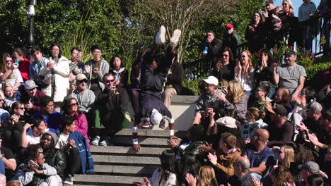 Handstand-street-performer-going-down-stairs-through-crowd-applauding