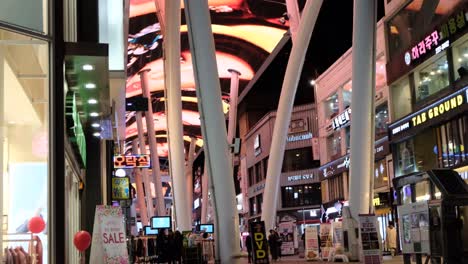 Una-Vista-De-Una-Calle-Comercial-Con-Luces,-Pancartas-Y-Anuncios-Por-Todas-Partes-Por-La-Noche