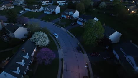 Aerial-top-down-shot-of-luxury-suburban-houses-with-colorful-trees-at-dusk