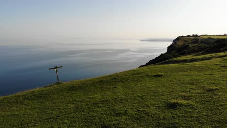 Antena-Sobre-Un-Coche-Plateado-Estacionado-En-La-Parte-Superior-De-Littlecombe-Shoot-Bay-Durante-El-Crepúsculo