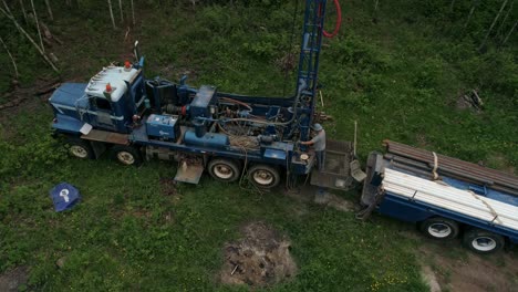 Overhead-rotating-aerial-view-of-a-water-well-drilling-rig-in-operation-in-rural-area