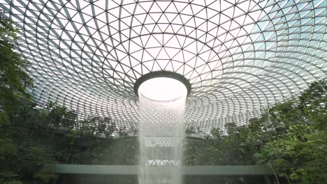 POV-Looking-up-at-the-magnificent-view-of-the-world's-tallest-indoor-waterfall-in-Jewel-Changi-Airport-in-Singapore-slowmo