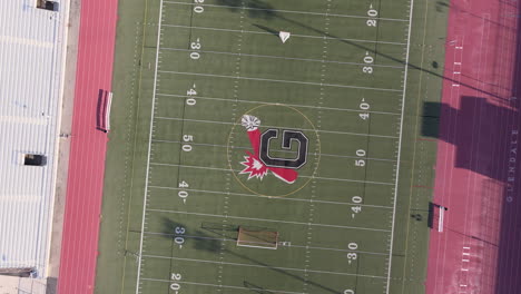 Aerial-birds-eye-rising-and-spinning-over-football-field-in-Glendale,-California