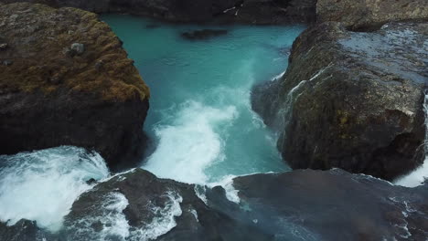 Aerial-View-of-Natural-Beauty-of-Iceland-Highlands,-Glacial-River-and-Waterfall-Between-Volcanic-Cliffs